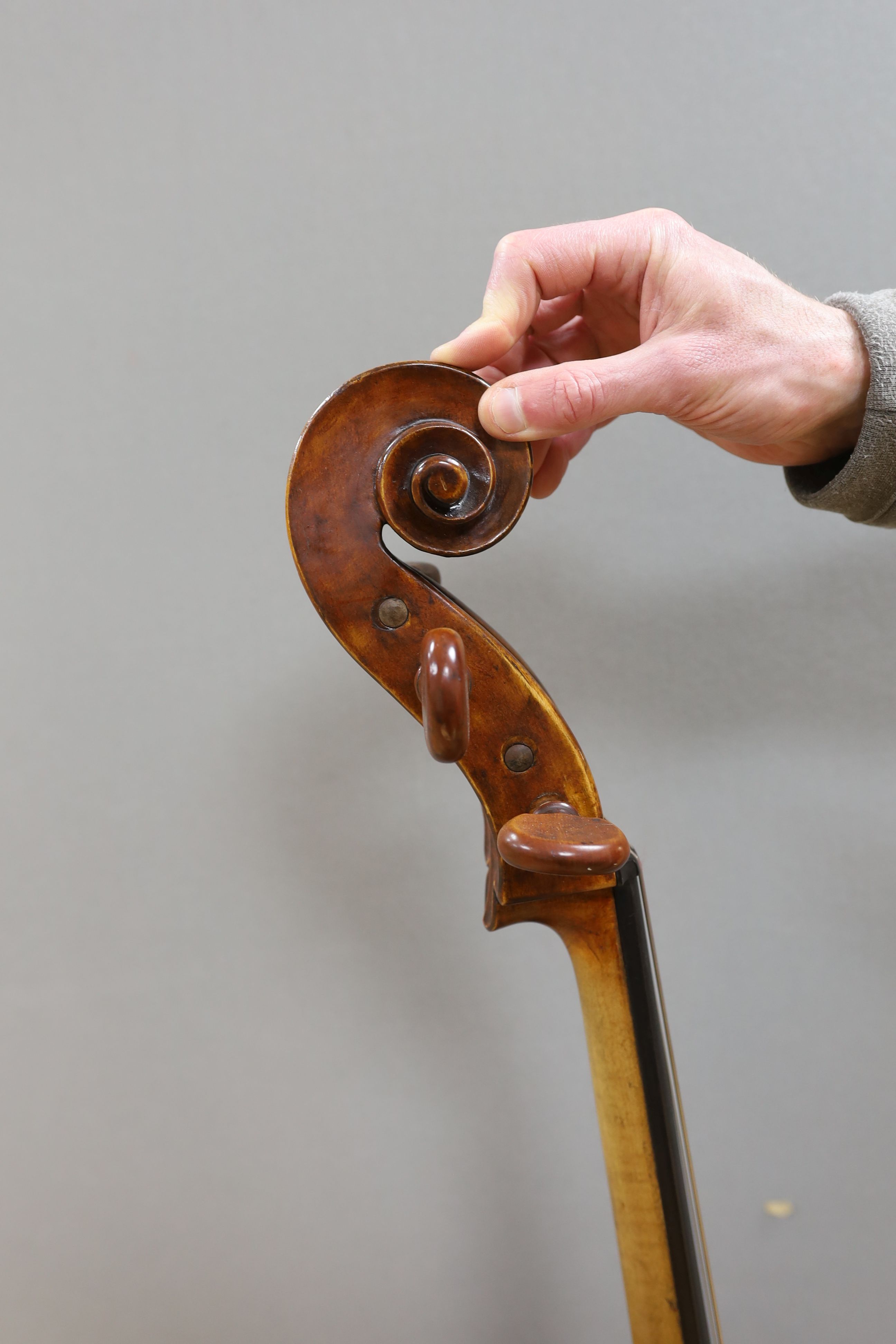 A cased early 20th century ‘cello, length of body 75.5cm, with two spare bridges, and spare strings